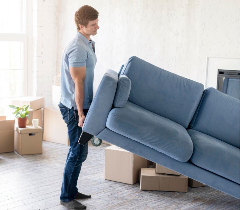 a boy lifting sofa for relocation