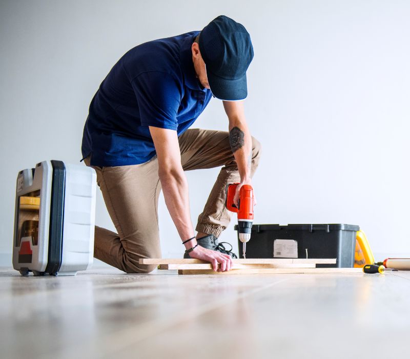 a boy wearing hat and drilling wood