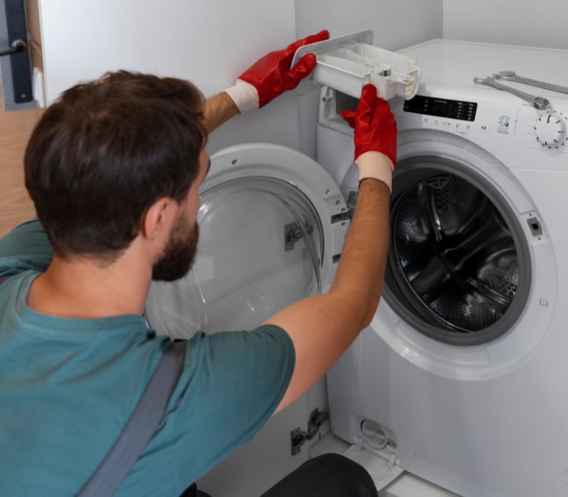 a boy with gloves repairing dryer