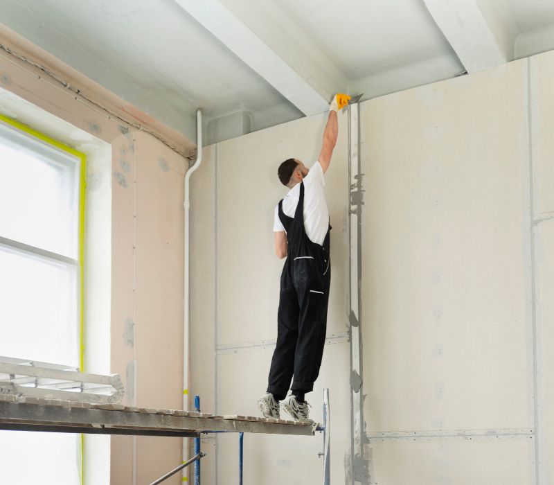 a boy is repairing wall before end tenancy painting