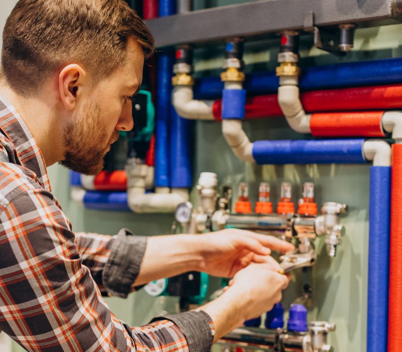 a plumber is fixing pipes with wrench